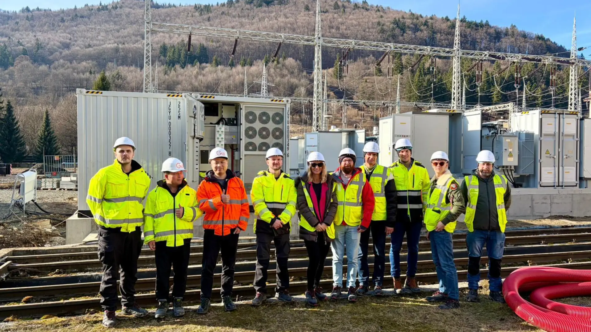 BESSMONT and OFZ project team in high-visibility clothing in front of the installed battery storage system